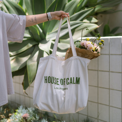 House of Calm tote bag filled with flowers and vegetables at farmers market